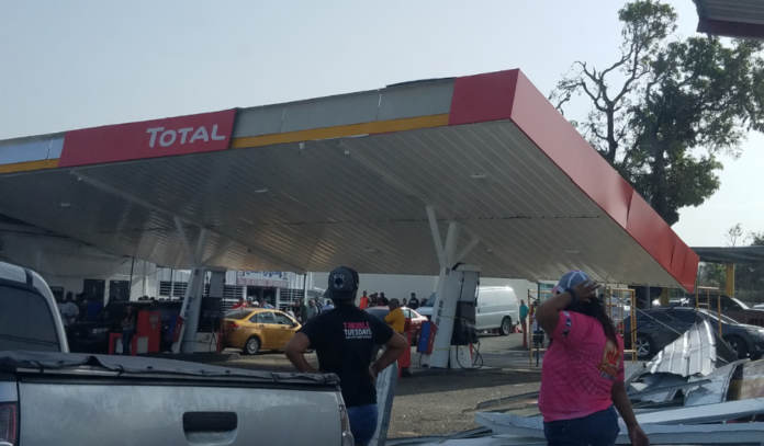 Ciudadanos se abastecen de combustible en una estación de Juana Díaz cuyo techo colapsó parcialmente tras el paso del huracán María.