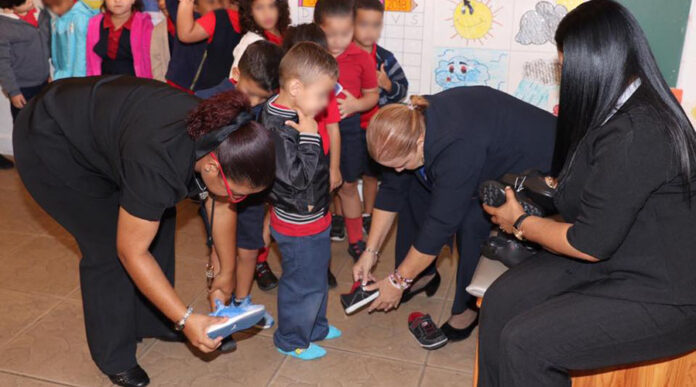 Niños coameños recibieron hoy un par de zapatos de la marca Sketches como parte de un acto de beneficencia de esta empresa, la Fundación Carlos Beltrán y Delivering Good. (Facebook / Municipio Autónomo de Coamo)