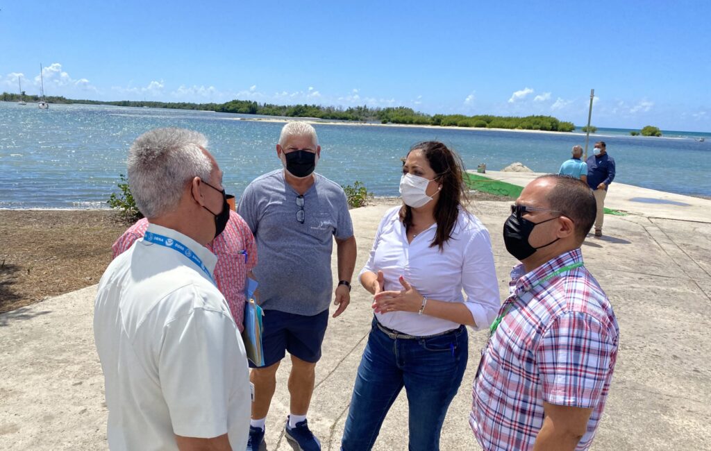 La representante Estrella Martínez Soto dialoga con pescadores durante la vista ocupar en el área de la rampa del barrio Playa de Santa Isabel. (Suministrada)